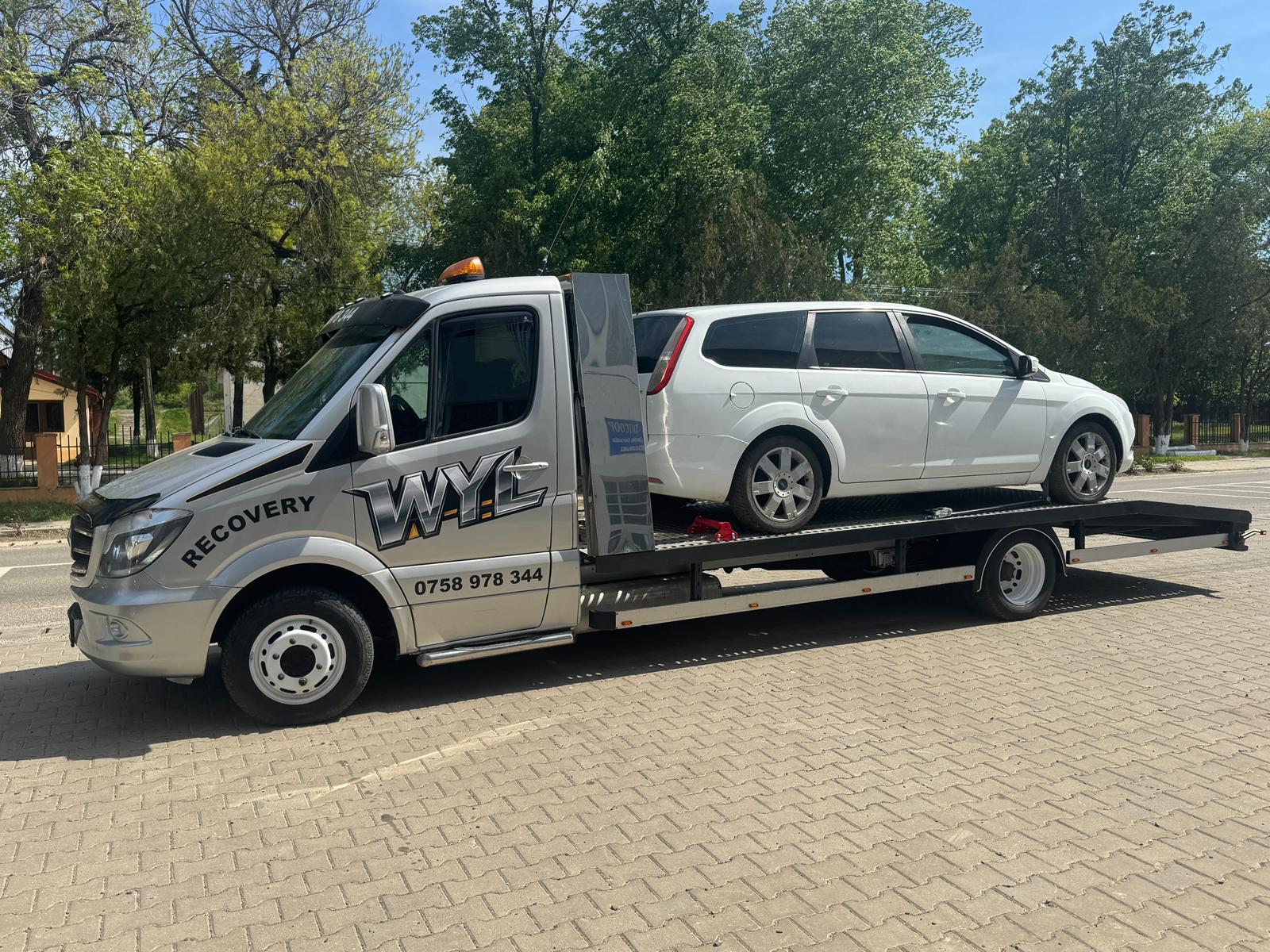 Autoturism alb transportat pe platformă auto în Botoșani
